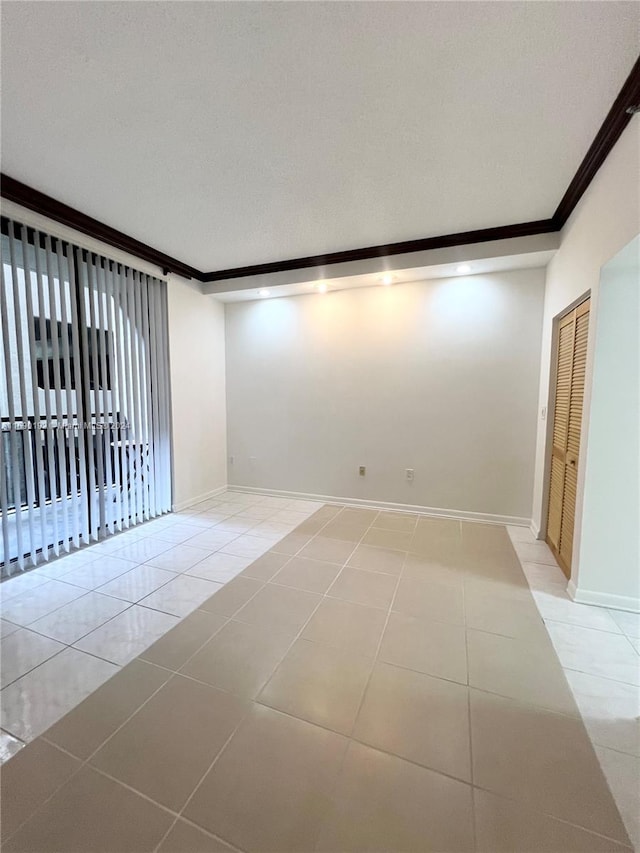 unfurnished room featuring light tile patterned floors and crown molding