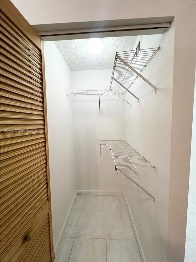 walk in closet with tile patterned floors