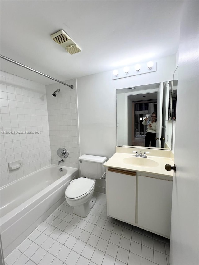 full bathroom with vanity, tiled shower / bath combo, toilet, and tile patterned flooring