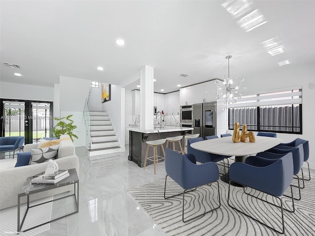 dining area featuring french doors, a notable chandelier, and sink