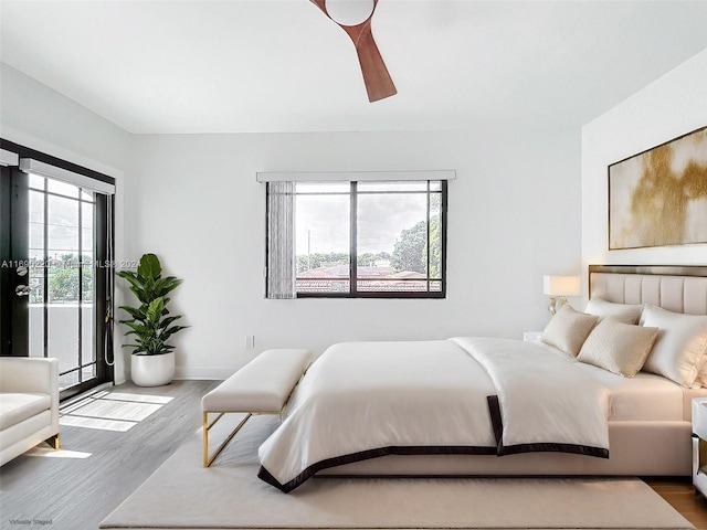 bedroom featuring access to exterior, hardwood / wood-style floors, and ceiling fan