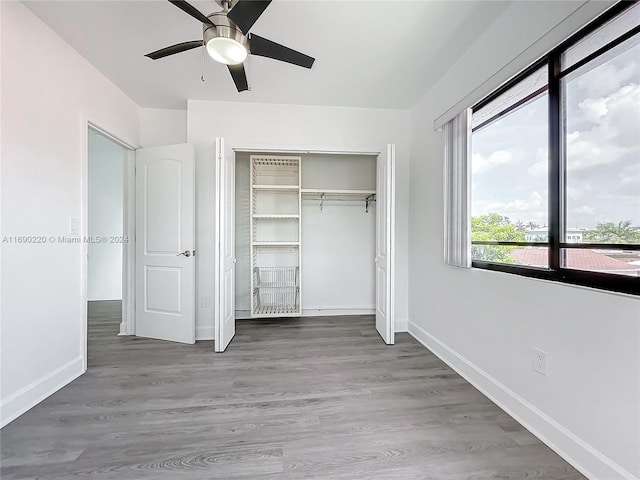 unfurnished bedroom with hardwood / wood-style floors, ceiling fan, and a closet