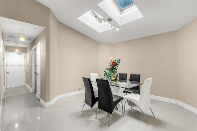 dining space with light tile patterned floors and a skylight