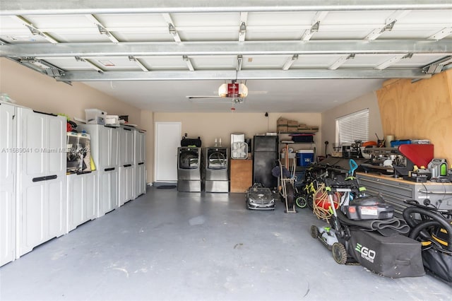 garage with black refrigerator, washer and clothes dryer, and a garage door opener