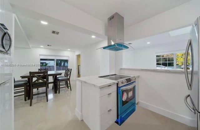 kitchen with light stone counters, white cabinets, kitchen peninsula, island exhaust hood, and appliances with stainless steel finishes