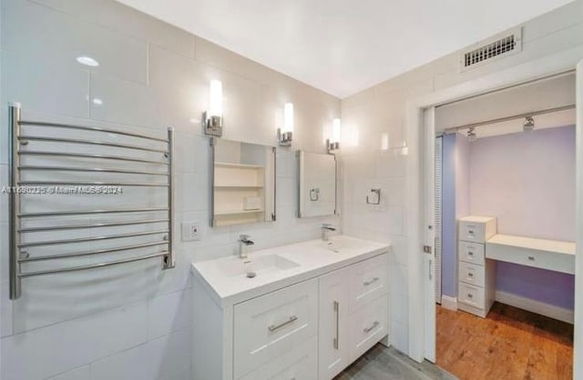 bathroom with radiator heating unit, vanity, and hardwood / wood-style flooring