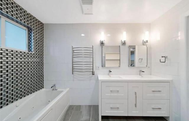 bathroom featuring vanity, tile walls, and a tub