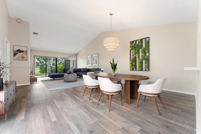 dining space featuring dark hardwood / wood-style flooring and vaulted ceiling