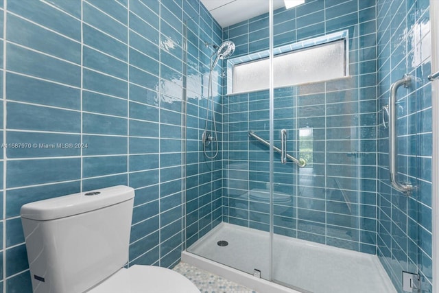 bathroom featuring an enclosed shower, toilet, and tile walls