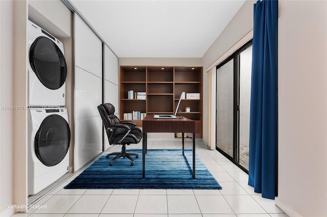 office space with light tile patterned floors and stacked washing maching and dryer