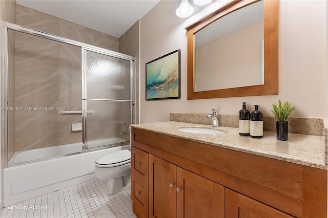 full bathroom featuring tile patterned flooring, vanity, combined bath / shower with glass door, and toilet