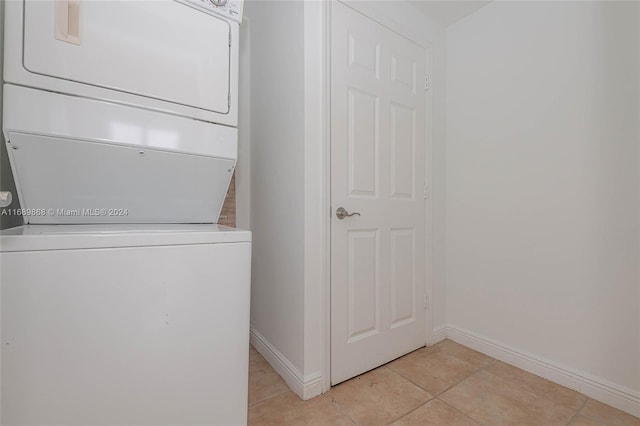 washroom with light tile patterned floors and stacked washer / dryer