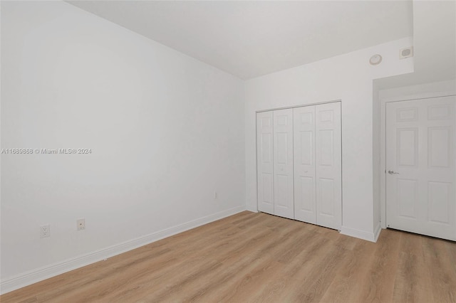 unfurnished bedroom with light hardwood / wood-style floors and a closet