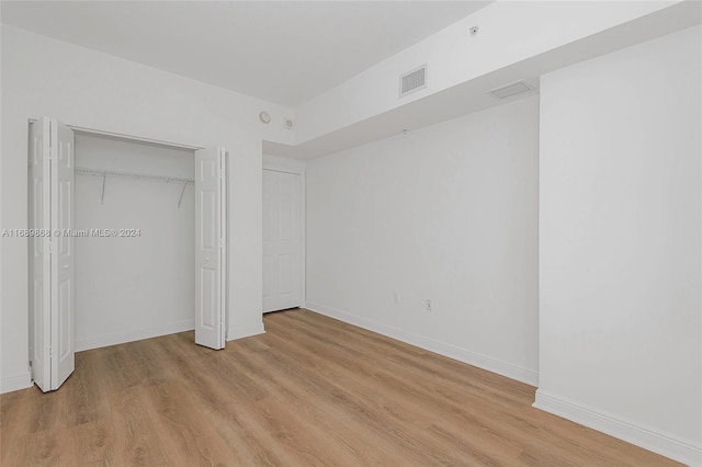 unfurnished bedroom featuring a closet and light wood-type flooring