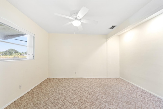 carpeted spare room featuring ceiling fan