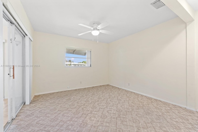 unfurnished bedroom with light colored carpet, ceiling fan, and a closet