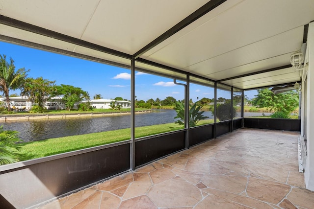 unfurnished sunroom featuring a water view