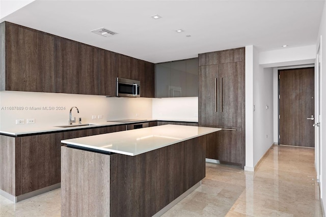 kitchen featuring a kitchen island, dark brown cabinets, sink, a breakfast bar area, and black electric cooktop