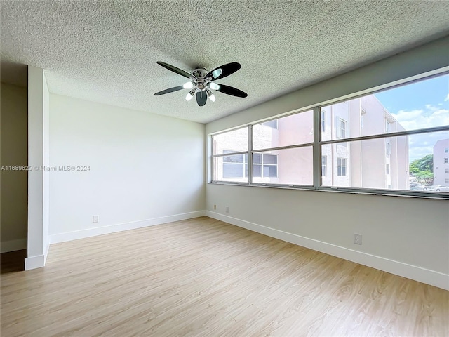 unfurnished room featuring ceiling fan, light hardwood / wood-style floors, and a textured ceiling