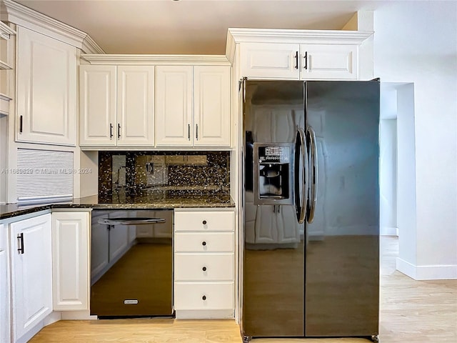 kitchen featuring white cabinetry, black dishwasher, stainless steel fridge, dark stone counters, and light wood-type flooring