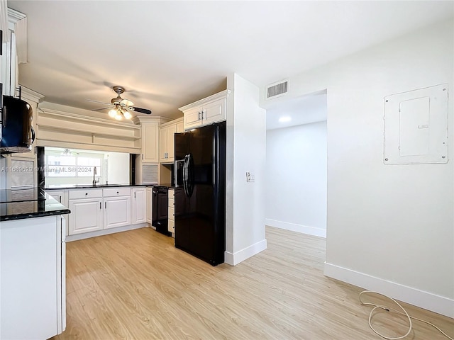 kitchen with white cabinetry, ceiling fan, black fridge, light hardwood / wood-style flooring, and electric panel