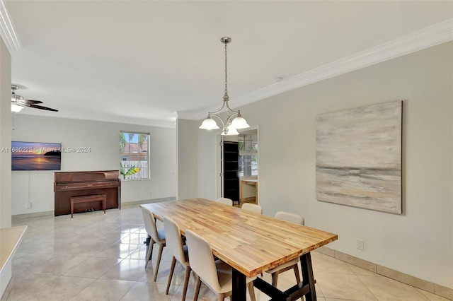 dining space with ornamental molding, ceiling fan with notable chandelier, and light tile patterned flooring