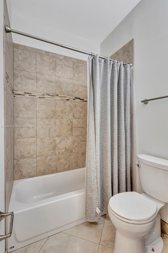 bathroom featuring shower / bath combo with shower curtain, tile patterned floors, and toilet