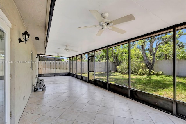 unfurnished sunroom with ceiling fan