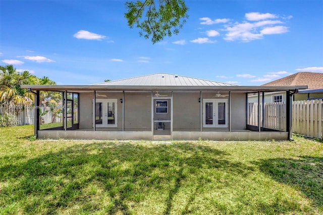 back of house with french doors and a lawn