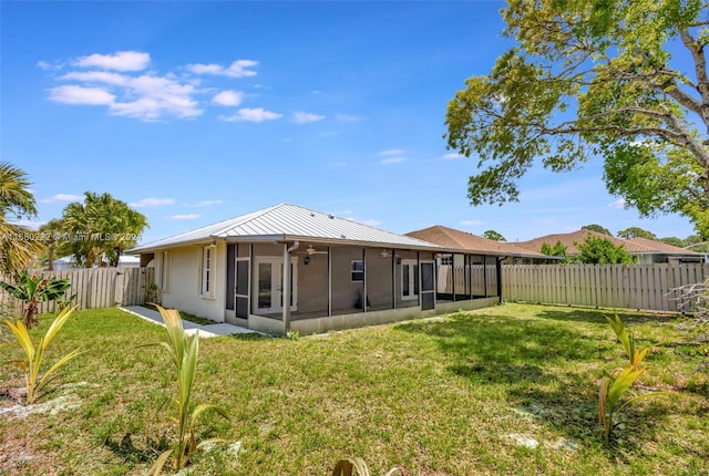 back of property with a sunroom and a yard