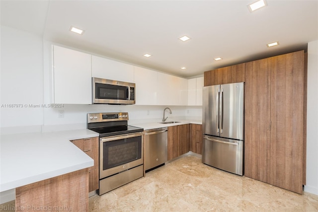 kitchen with white cabinets, sink, and appliances with stainless steel finishes