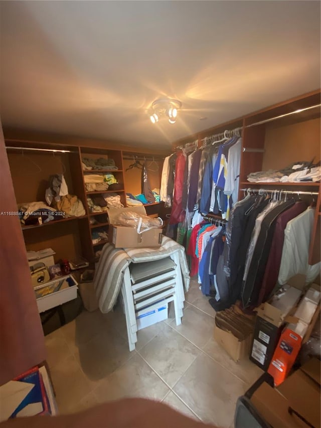 walk in closet with light tile patterned floors