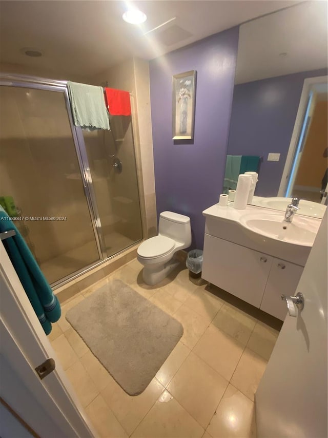 bathroom with tile patterned floors, vanity, toilet, and an enclosed shower