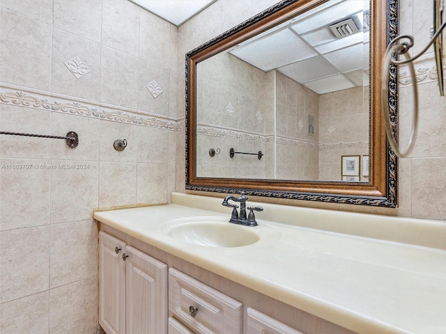 bathroom featuring vanity and tile walls