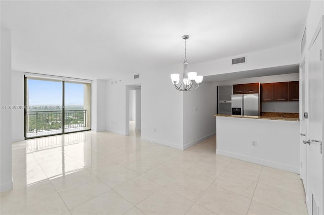 tiled empty room featuring a wall of windows and a notable chandelier