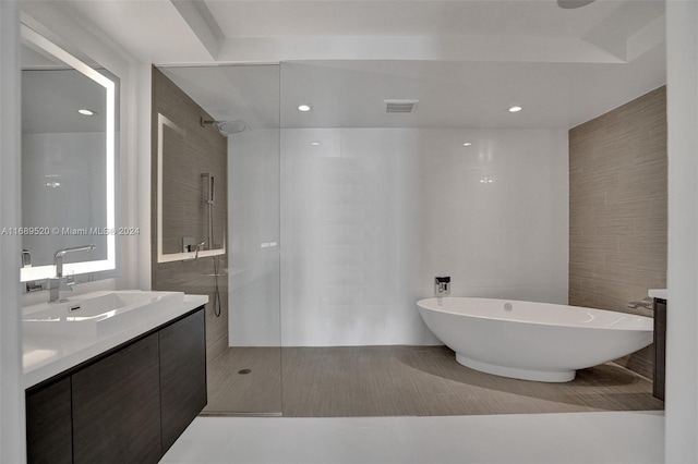 bathroom with tile patterned flooring, vanity, separate shower and tub, and tile walls