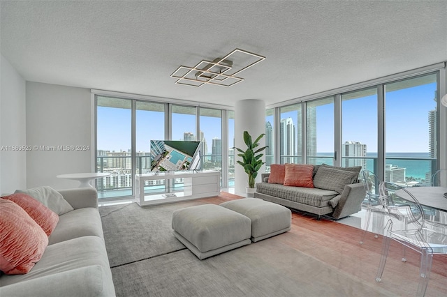 living room featuring a wealth of natural light, a wall of windows, and a textured ceiling