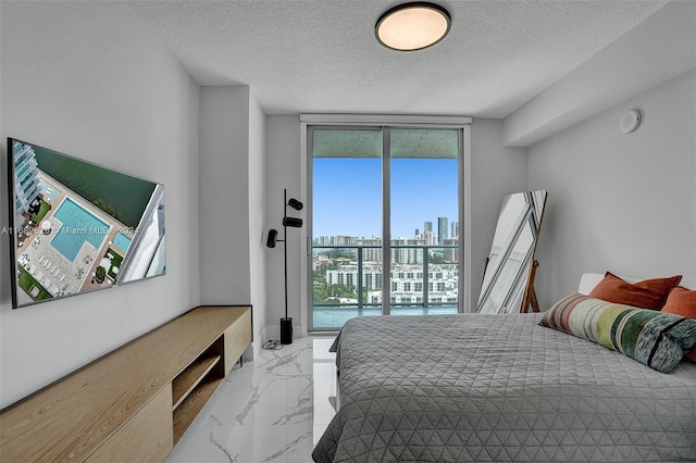 330 Sunny Isles Blvd Unit 5-2207, Sunny Isles Beach, FL 33160 - bedroom featuring marble look tile flooring, access to exterior, a textured ceiling, a skyline view, and expansive windows