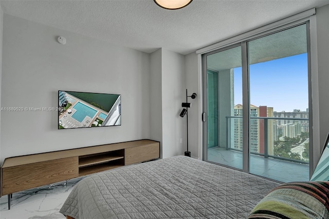 bedroom featuring a textured ceiling, access to outside, expansive windows, and multiple windows