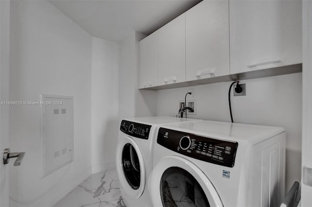 laundry room featuring washing machine and dryer and cabinets