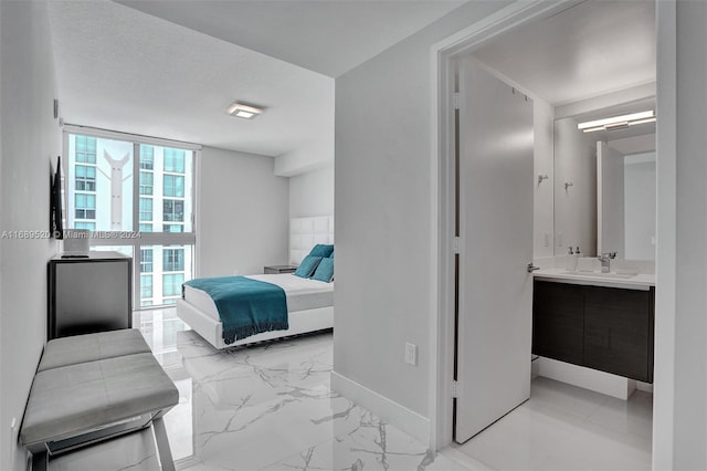 330 Sunny Isles Blvd Unit 5-2207, Sunny Isles Beach, FL 33160 - bedroom with a sink, light marble finish flooring, baseboards, and ensuite bathroom
