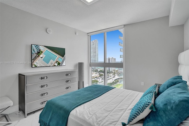 bedroom with expansive windows and a textured ceiling