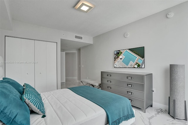 bedroom featuring a textured ceiling and a closet