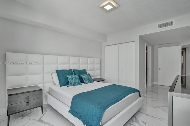 bedroom featuring a textured ceiling and a closet