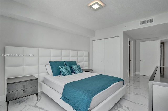 330 Sunny Isles Blvd Unit 5-2207, Sunny Isles Beach, FL 33160 - bedroom with marble finish flooring, a closet, a textured ceiling, and baseboards