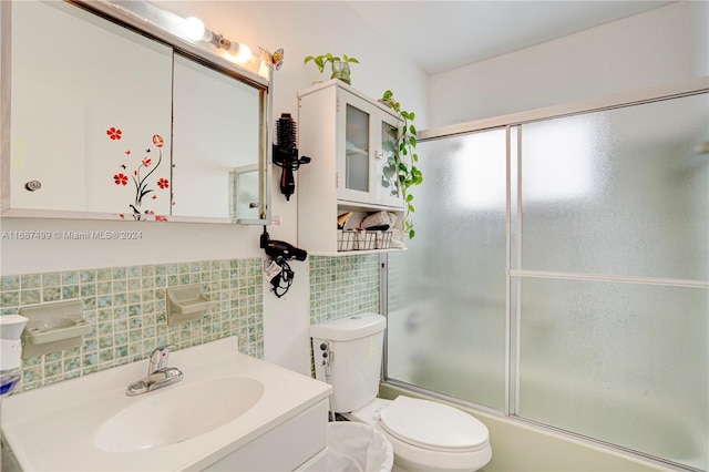 full bathroom featuring backsplash, vanity, tile walls, enclosed tub / shower combo, and toilet