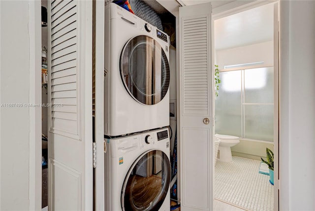 laundry area featuring tile patterned floors and stacked washer and clothes dryer