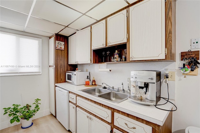 kitchen featuring sink, white cabinets, a drop ceiling, and white appliances