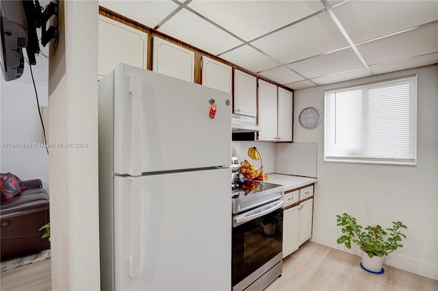 kitchen with stainless steel range with electric stovetop, white refrigerator, white cabinetry, and light hardwood / wood-style flooring