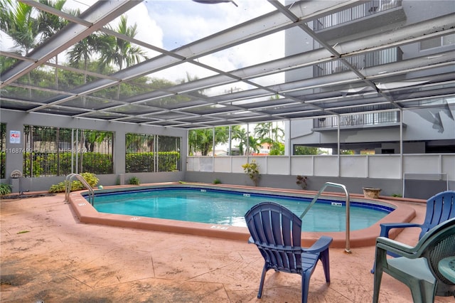 view of swimming pool featuring a lanai and a patio